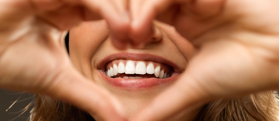 Hands creating heart shape around mouth